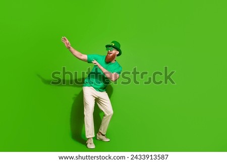 Full size photo of crazy overjoyed man have fun dancing empty space isolated on green color background