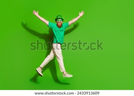 Full size profile photo of crazy charismatic person jump raise arms empty space isolated on green color background