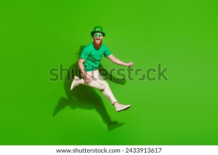 Full body profile portrait of carefree person jump raise fist rejoice empty space isolated on green color background