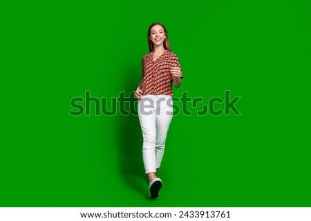 Full size photo of optimistic nice teenager wear print blouse white trousers go shopping isolated on vibrant green color background