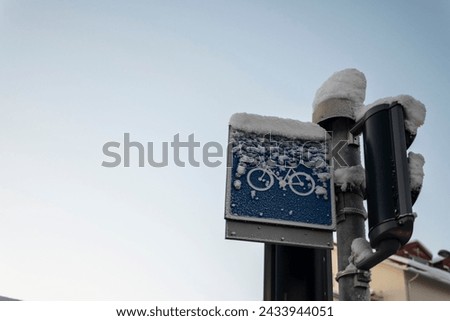 Cycling traffic signal covered in snow on a winter urban still