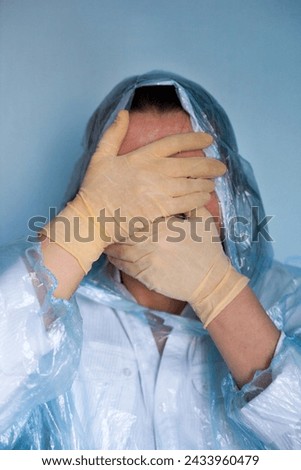 Woman in a protective suit closing her face. Distressed woman. Coronavirus (Covid-19) disease outbreak.  Royalty-Free Stock Photo #2433960479