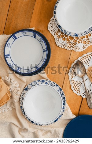 flatlay vintage grandma table setup with 3 plates bowl empty over crochet table runners and rustic wood board table 