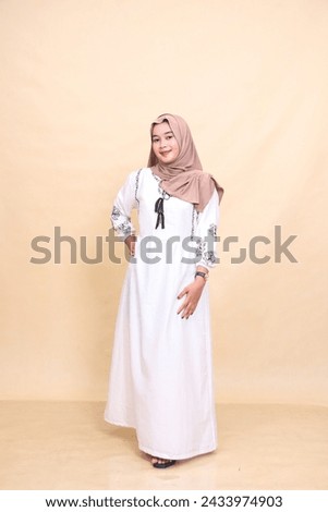 Full body portrait of a beautiful young indonesian Muslim woman in hijab posing smiling holding waist and dress. for advertising, content, banners and Ramadan