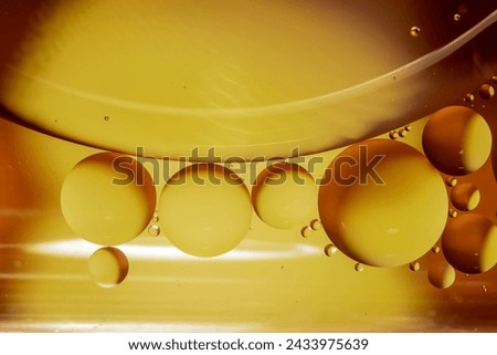 Macro photography. Orange drops of oil or serum texture background. Oil drops on the water's surface. Royalty-Free Stock Photo #2433975639
