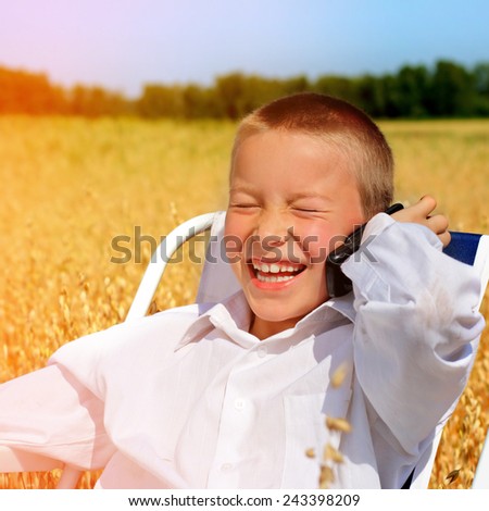 Toned Photo of Cheerful Kid with Cellphone in the Wheat Field