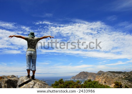 happy woman with arms wide open at the coast