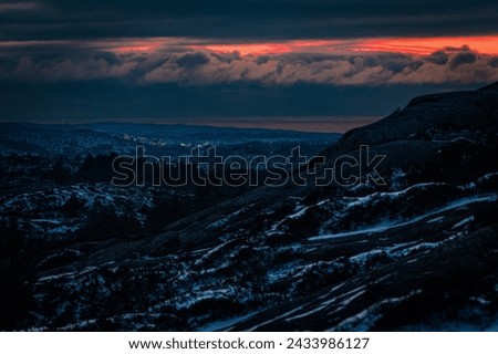 Winter in the low mountains of Bohuslän, the lights of a small town and the Skagerrak ocean in the background. Royalty-Free Stock Photo #2433986127