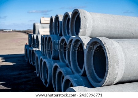 Stacked concrete casing pipes for sewer and water in the sky Royalty-Free Stock Photo #2433996771