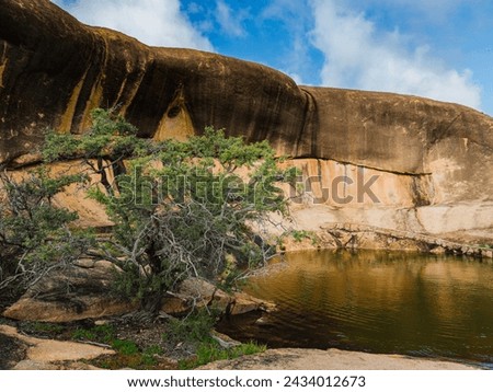 Beringbooding Rock in the eastern Wheatbelt region of Western Australia is a spectacular natural granite rock formation with a large gnamma hole. An outback monolith with caves and a wave shaped wall.