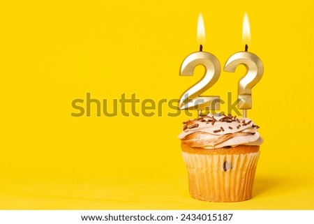 Birthday Cupcake With Candle Number 2 And Question Mark - Photo On Yellow Background.