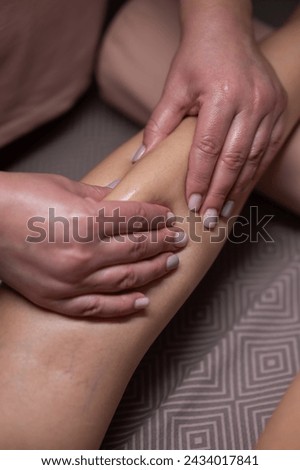 Close-up of a woman's leg massage in a salon. Vertical photo.