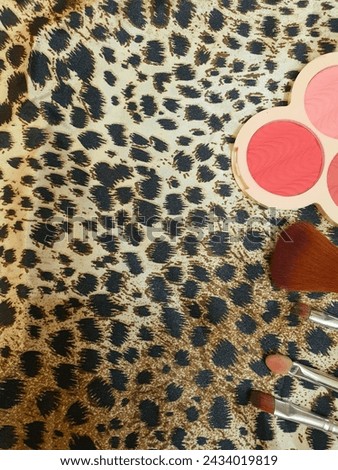Makeup brushes and blush on with a beautiful cheetah print background 