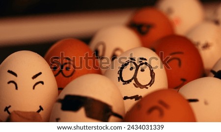 Fotografía de huevos blancos y marrones con caras graciosas. 