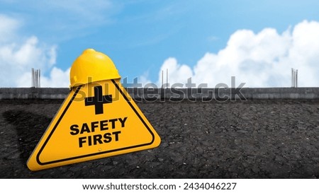 Safety first with yellow sign on asphalt road and yellow helmet as a warning concept of industrial attention for employee awareness. Avoid any unnecessary risk live safely and healthcare attention 