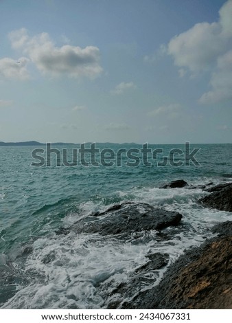 The sea, mountains, and waves crashing against the rocks.