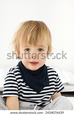Close-up shoulder photo ID identification card little cute 2 years blonde boy isolated white background. Male kid person identity card passport. Portrait child looking at camera document striped bib