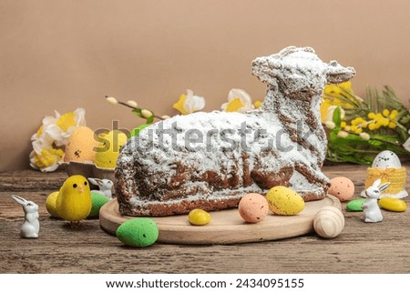 Easter lamb cake with traditional spring decor. Baked sweet dessert with sugar icing. Festive background, classic holiday symbols. Wooden background, copy space Royalty-Free Stock Photo #2434095155