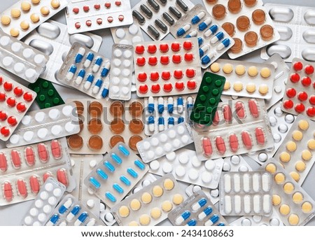 Health care concept. Checking medicine cabinet pills for expired medicines. Expiration date is indicated on packages of medicines. Pile of pills on table. Medicines background. Flat lay, close-up Royalty-Free Stock Photo #2434108663
