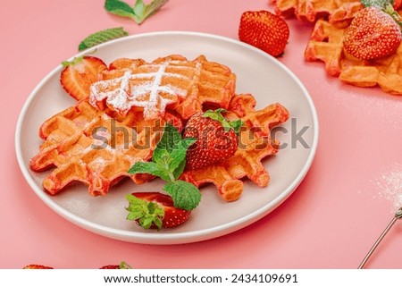 Homemade Belgian Waffles with strawberries. Gluten-free red dessert, fresh fruits and basil. Sweet sugar powder, trendy pink background, close up