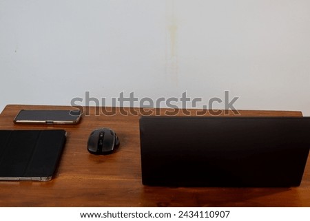 work desk with laptop, tablet, smartphone and mouse