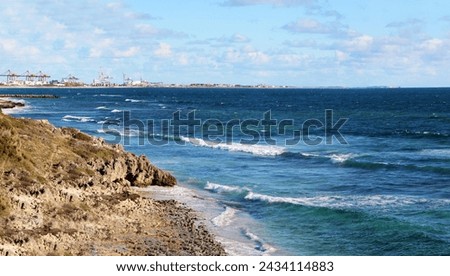 The Indian Ocean washes the rocky cliffs between Cottesloe Beach and Leighton Beach ,Perth, Western Australia on a cloudy windy afternoon in late autumn in this scenic picturesque panorama.