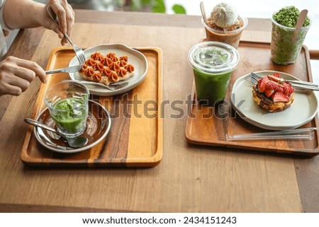 Woman take croffles, delicious breakfast. Croissant as waffle. Dessert and drinks table. Vertical format. Flat lay concept. Royalty-Free Stock Photo #2434151243