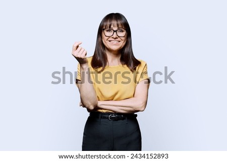 Portrait of smiling mature confident woman on white studio background
