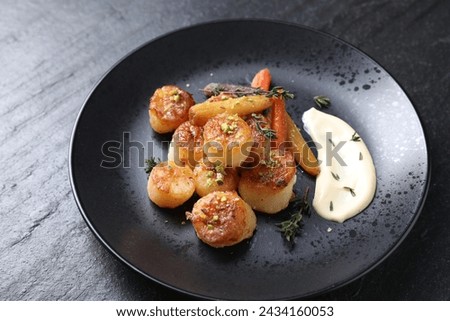 Delicious fried scallops on dark gray textured table, closeup
