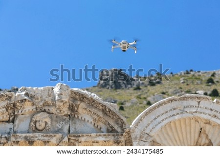 Drone hovers over Sagalassos ruins, capturing photos, ancient carved stones, clear sky, mountain backdrop. Aglasun, Burdur, Turkey (Turkiye)