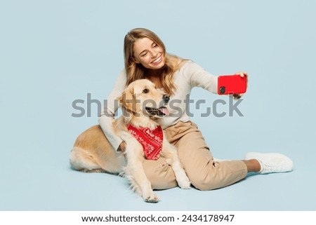 Full body young owner woman with her best friend retriever dog wear casual clothes doing selfie shot on mobile cell phone isolated on plain light blue background studio. Take care about pet concept