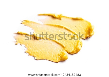 Yellow cosmetic cream swatch smear smudge isolated on white background. Stroke of rich body butter,  clay cosmetic product. Royalty-Free Stock Photo #2434187483