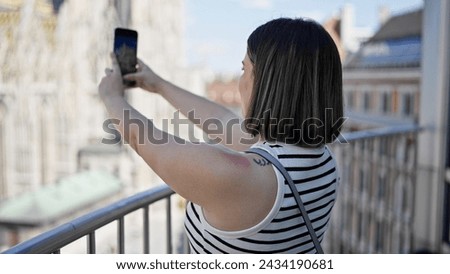 Young beautiful hispanic woman taking pictures at St. Stephen's Cathedral