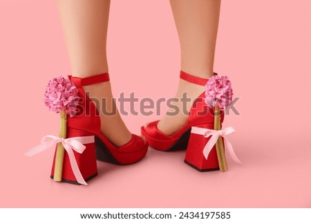 Legs of beautiful young woman in ankle straps heels with hyacinth flowers on pink background Royalty-Free Stock Photo #2434197585