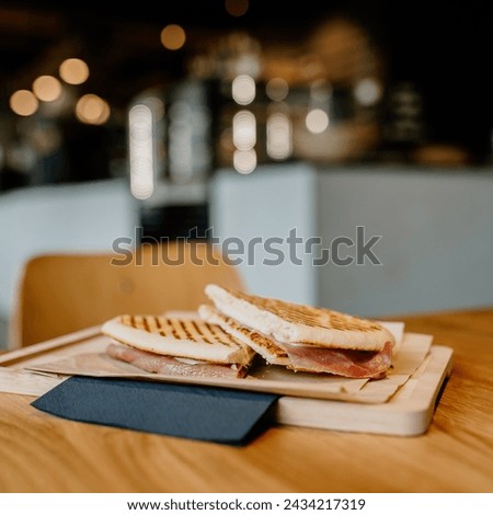 Savor the deliciousness of this gourmet panini, served fresh and hot in a cozy restaurant ambiance. Indulge in the perfect blend of flavors and textures.