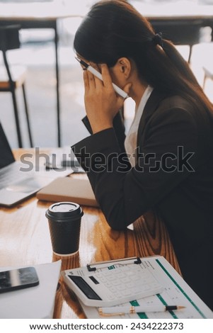Asian women are stressed while working on laptop, Tired asian businesswoman with headache at office, feeling sick at work, copy space Royalty-Free Stock Photo #2434222373