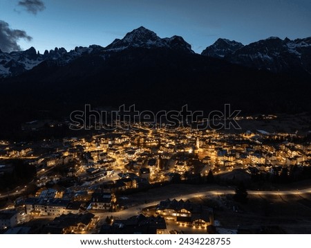 Aerial drone Andalo town at night  with mountains background in winter. Ski resort Paganella Andalo, Trentino-Alto Adige, Italy., Italian Dolomites,.Pagnella valley. Snow covered Italian Dolomites.