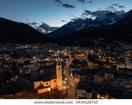 Aerial drone Andalo town at night  with mountains background in winter. Ski resort Paganella Andalo, Trentino-Alto Adige, Italy., Italian Dolomites,.Pagnella valley. Snow covered Italian Dolomites.