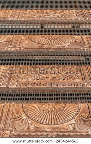 Antique cast iron steps with ornament on city street closeup. Vintage metal stairs decorated with elegant patterns outdoors. Historical landmark