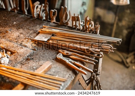 blacksmith workshop tools and metal ready for crafting Royalty-Free Stock Photo #2434247619