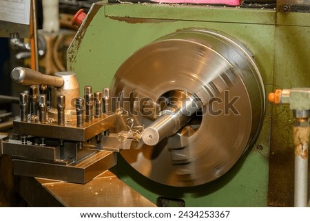 The lathe machine finish cut the metal shaft parts by lathe tools. The metalworking process by turning machine.
