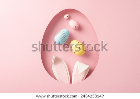 Springtime Easter vibe: top view photo of bunny wars, and colored eggs visible through an egg-shaped aperture on a pastel pink surface, with blank space for text