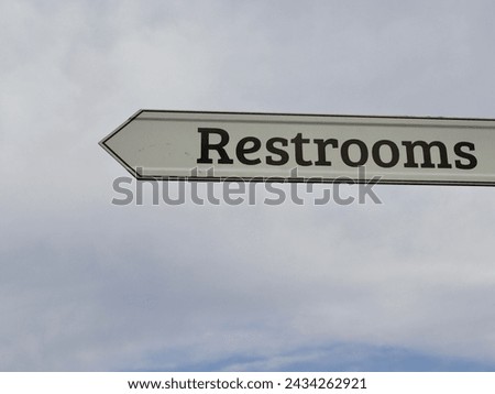 A close view of the brown and white restroom sign.