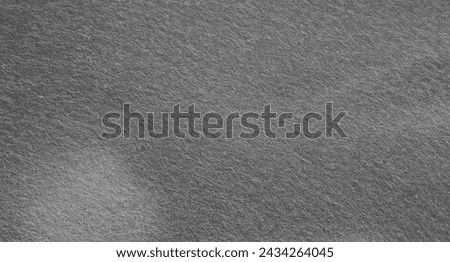 Dark grey felt material. Surface of felted fabric texture abstract background in gray color. High resolution photo.