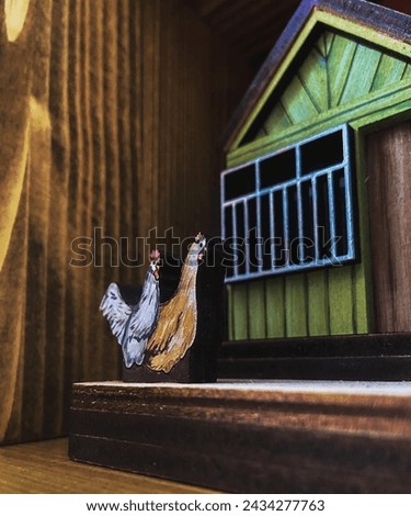 Small cartoon house and rooster in front of the house