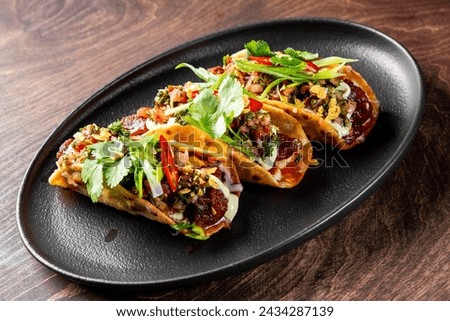 Delicious tacos with fresh garnish on a black plate, vibrant colors and textures inviting a bite