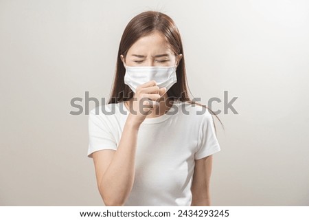 Unhealthy sickness, unwell asian young woman wearing mask coughing, have sore throat, suffering symptom cough feeling bad and healthcare of air pollution and dust, PM2.5 isolated white background. Royalty-Free Stock Photo #2434293245