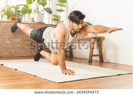Handsome fitness caucasian young man, guy wearing sportswear training strength muscles workout, exercise training in living room at home for healthy body strong athletic, fit active lifestyle. Royalty-Free Stock Photo #2434294473