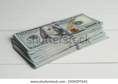 Money exchange. Stack of dollar banknotes on white wooden background