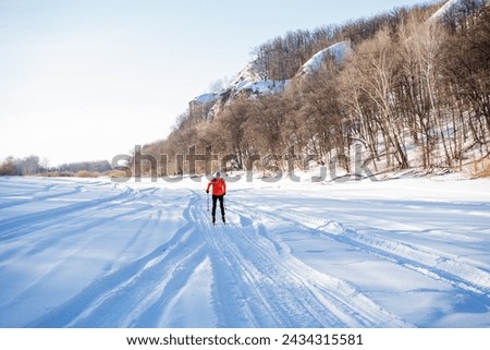 A guy is skiing in the snow on the background of a hill with a forest, ski training outside the city. High quality photo